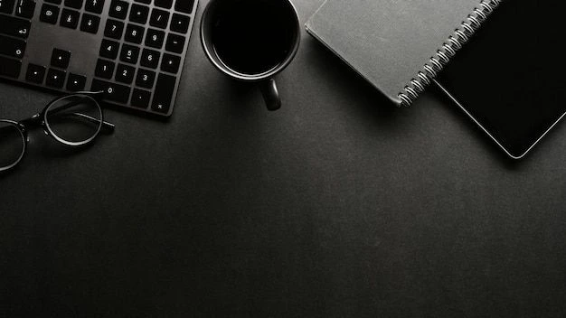 A minimalist black desk setup showing a keyboard, coffee mug, spiral notebook, tablet, and glasses against a dark background, representing the workspace of a professional digital marketing freelancer in Malappuram.